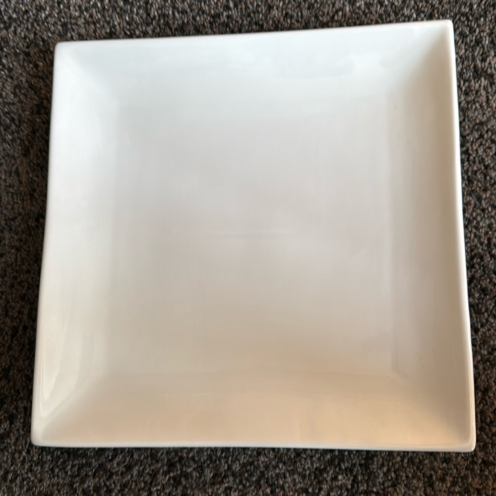 Two large, white square serving plates.